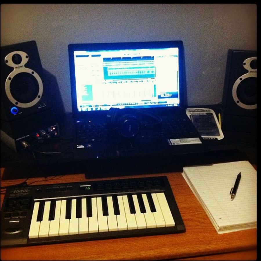 First setup: laptop running a DAW between two small monitors, audio interface, keyboard and a notepad